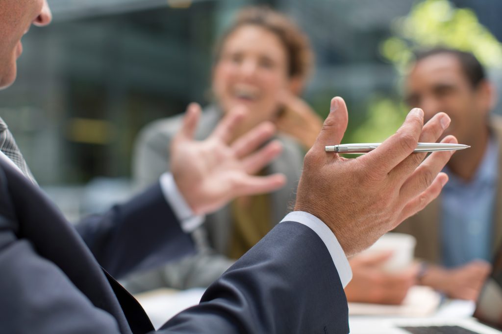 Businessman gesturing in meeting with colleagues
